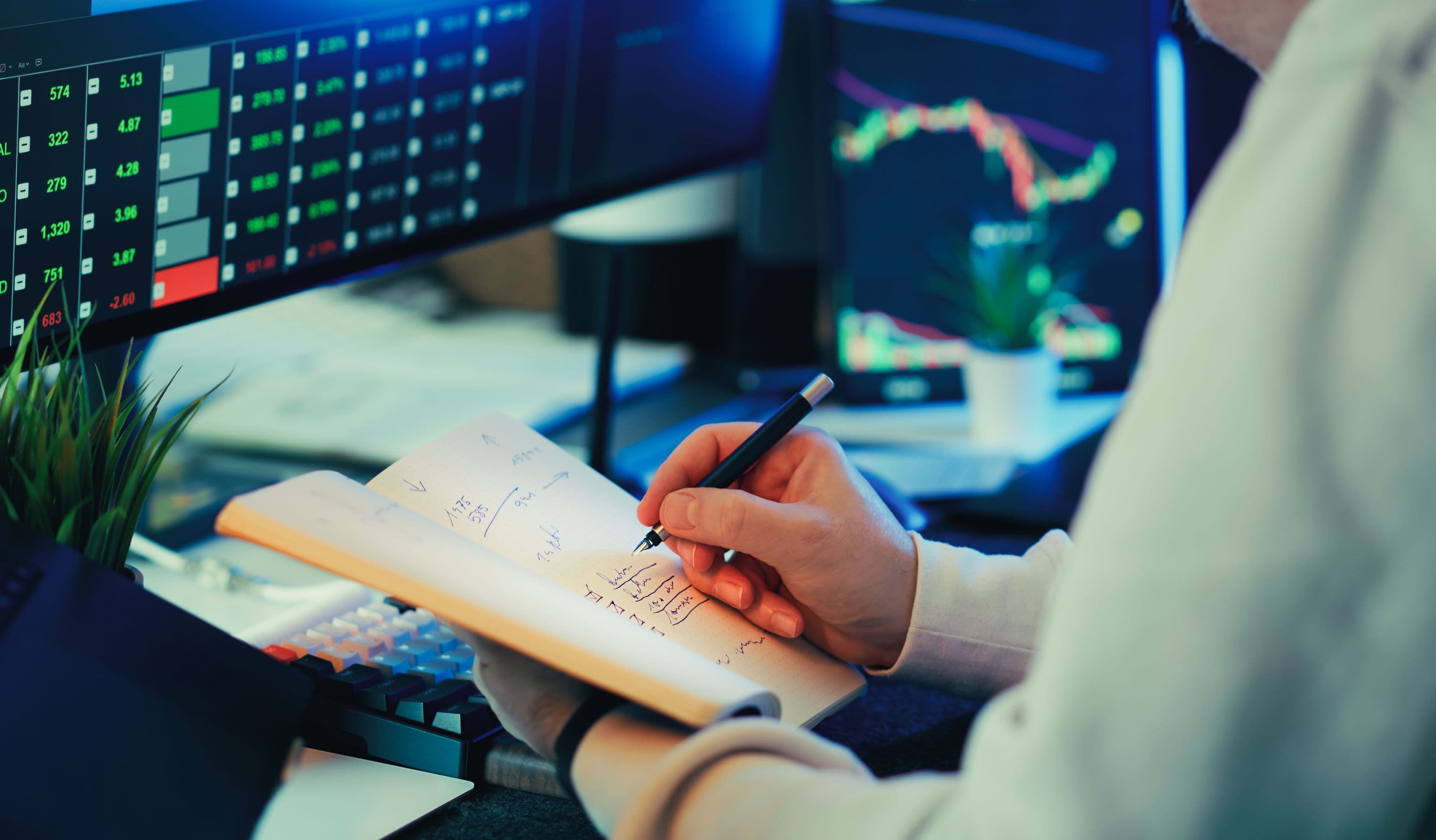 Person reviewing market data across multiple monitors