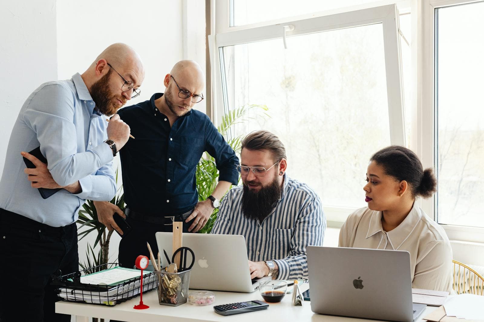 Team gathered around a laptop during an operations review meeting