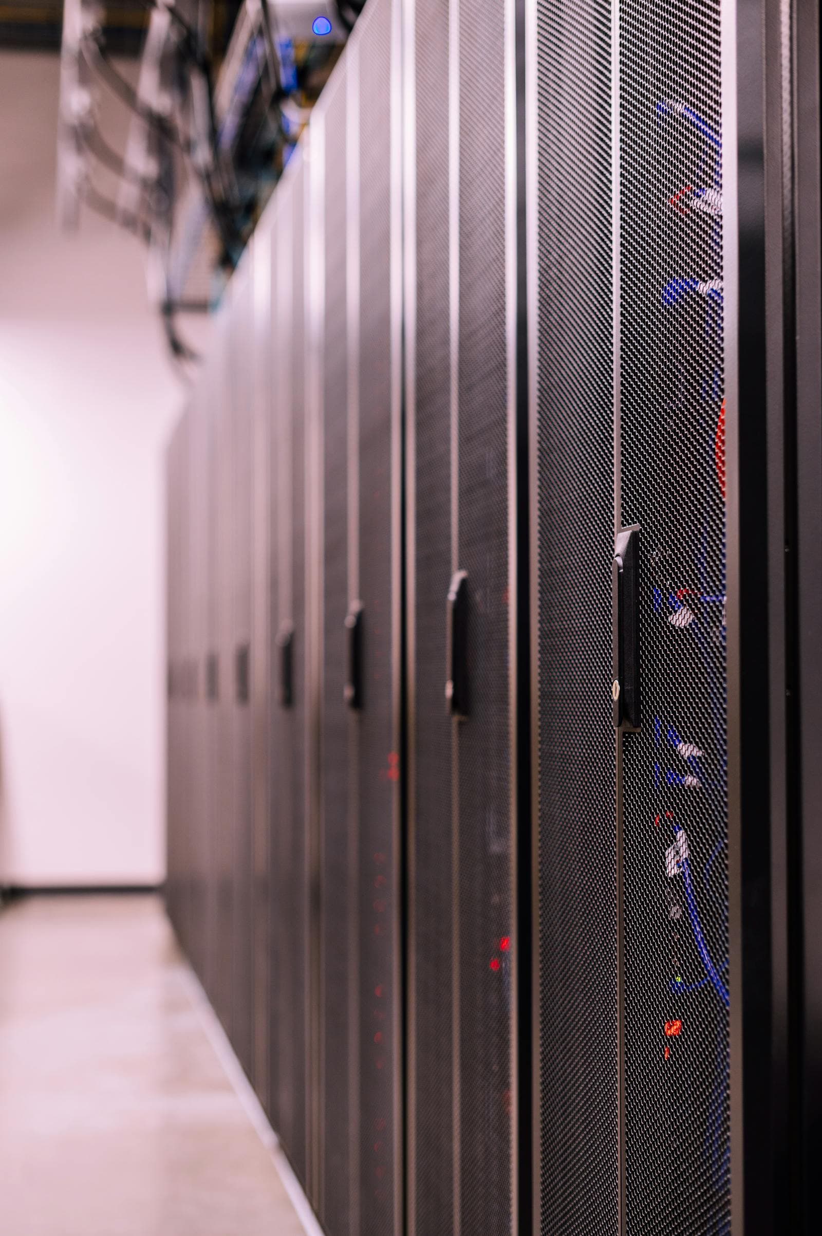 Row of black server racks with fiber cabling in a data room